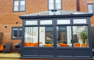 Anthracite grey conservatory facing out onto the back garden of a semi detached house