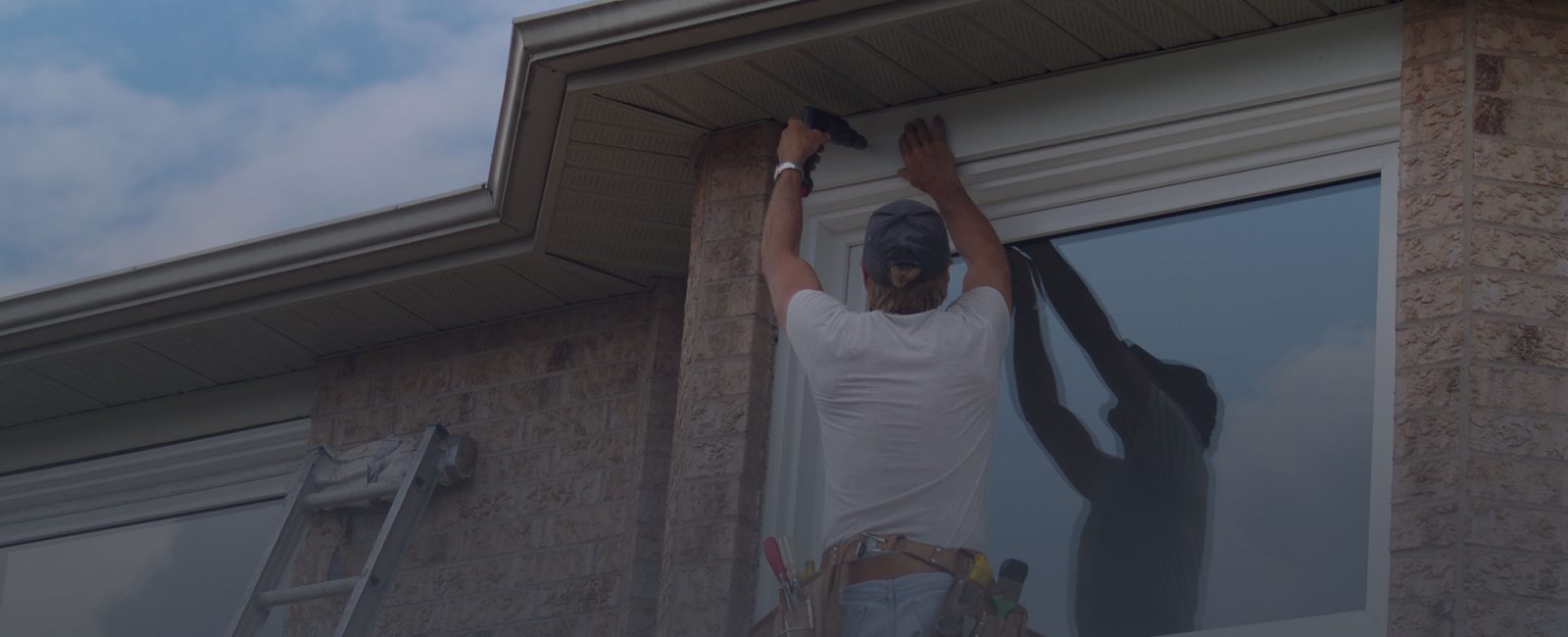 Grey gradient covered image of a man in a white t shirt replacing uPVC windows