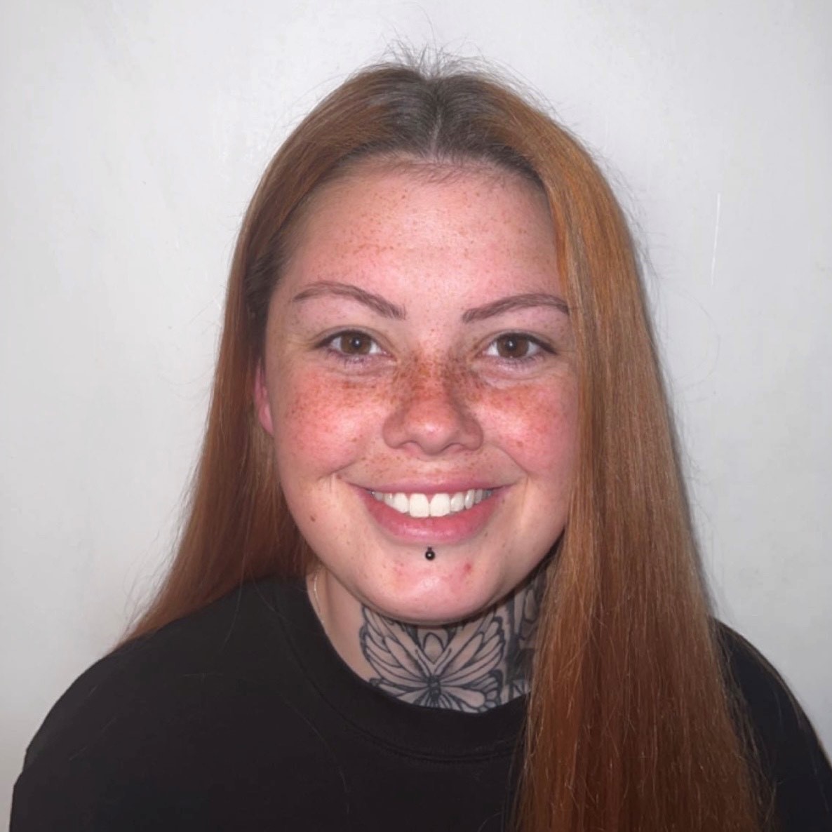 headshot of young female against plain white wall